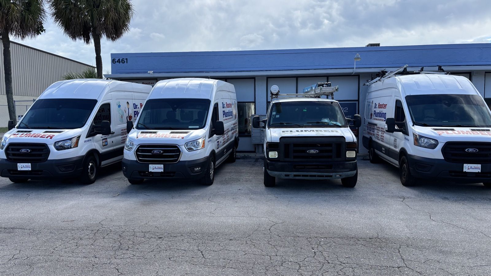 The Dr. Rooter Plumbing fleet parked outside the shop